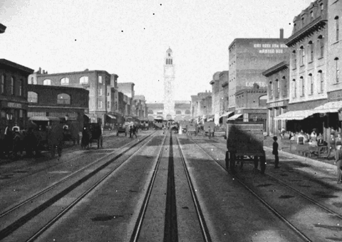 Blender 里重建的 1906 年旧金山 Market Street,黑白画面,镜头沿电车轨道走向渡轮大楼的钟楼